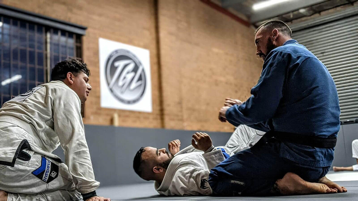the grappling lab brazilian jiu jitsu prestons instructor showing technique to 2 male students