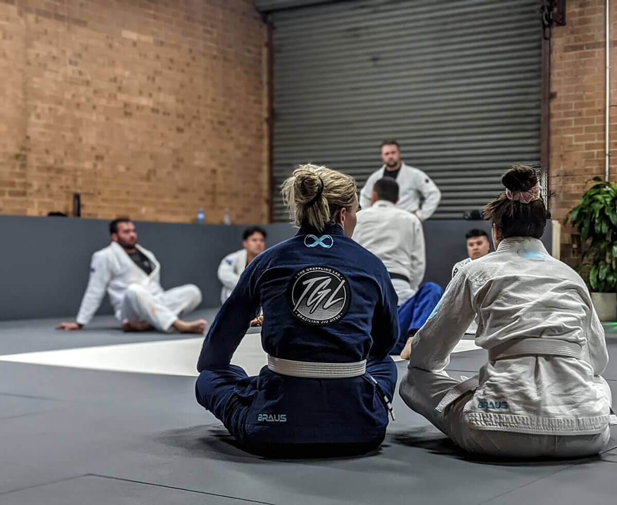 the grappling lab brazilian jiu jitsu prestons students watching instructor demonstrating gi technique